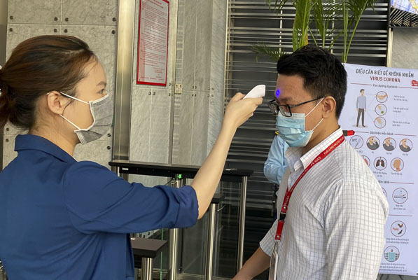 Đo thân nhiệt cho CBCNV tại sảnh tòa nhà trụ sở PV GAS tại TP.HCM.