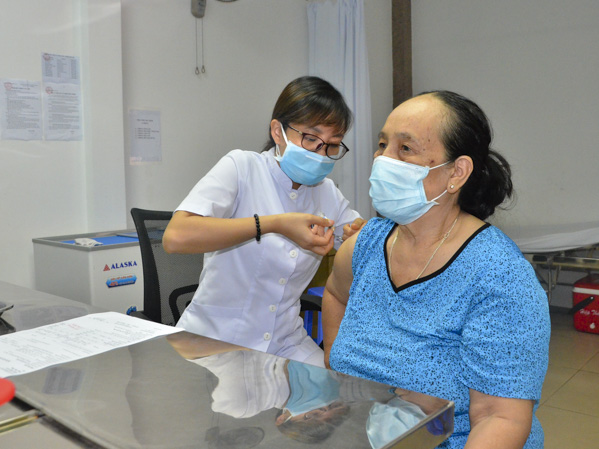 Bà Nguyễn Thị Hợi (1216/30A4, đường 30/4, phường 12, TP.Vũng Tàu, bìa phải) tiêm vắc xin phòng cúm tại Phòng khám Đa khoa Thiên Nam sáng 5/2.