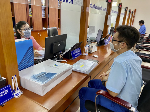 Anh Phan Duy Thanh, nhân viên Công ty TNHH POSCO Việt Nam (TX. Phú Mỹ) đến Bộ phận “một cửa” tập trung cấp tỉnh làm thủ tục cấp giấy phép lao động cho người lao động nước ngoài. Trong ảnh: Cả khách và công chức Bộ phận “một cửa” đều đeo khẩu trang trong khi làm việc.