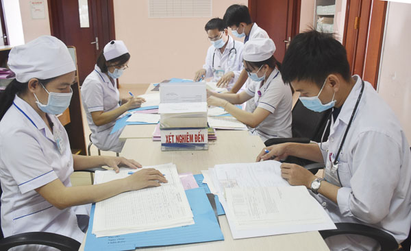 Các y, bác sĩ, nhân viên y tế tại Khoa Nhiễm trao đổi chuyên môn, làm thủ tục bệnh án cho bệnh nhân.