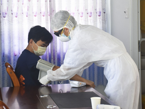 Nhân viên Điều dưỡng kiểm tra thân nhiệt cho một trường hợp đang ở trong khu cách ly tập trung của tỉnh.