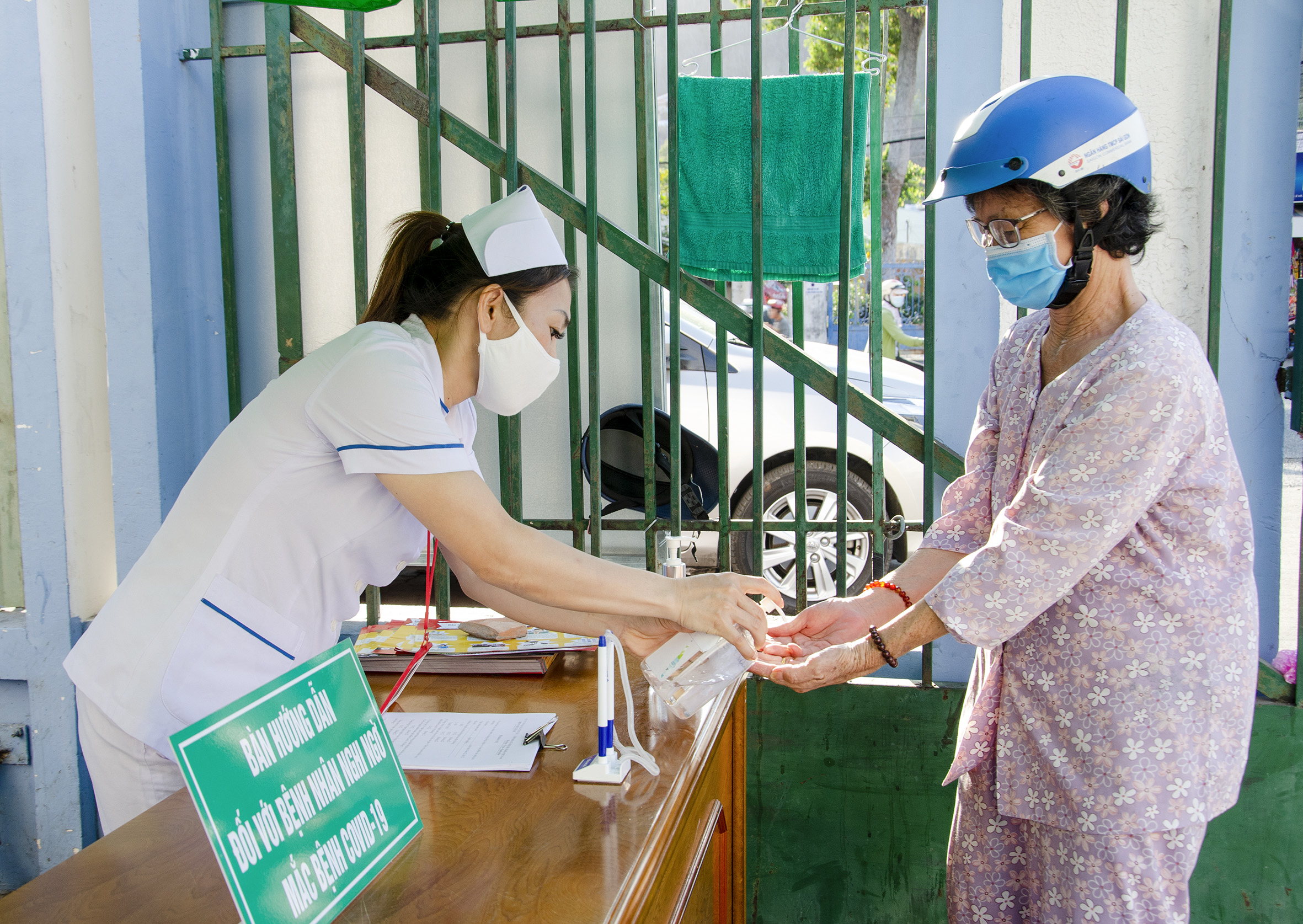 Nhân viên y tế Bệnh viện Lê Lợi hướng dẫn người dân rửa tay sát khuẩn phòng dịch bệnh COVID-19 trước và sau khi vào bệnh viện khám bệnh. 