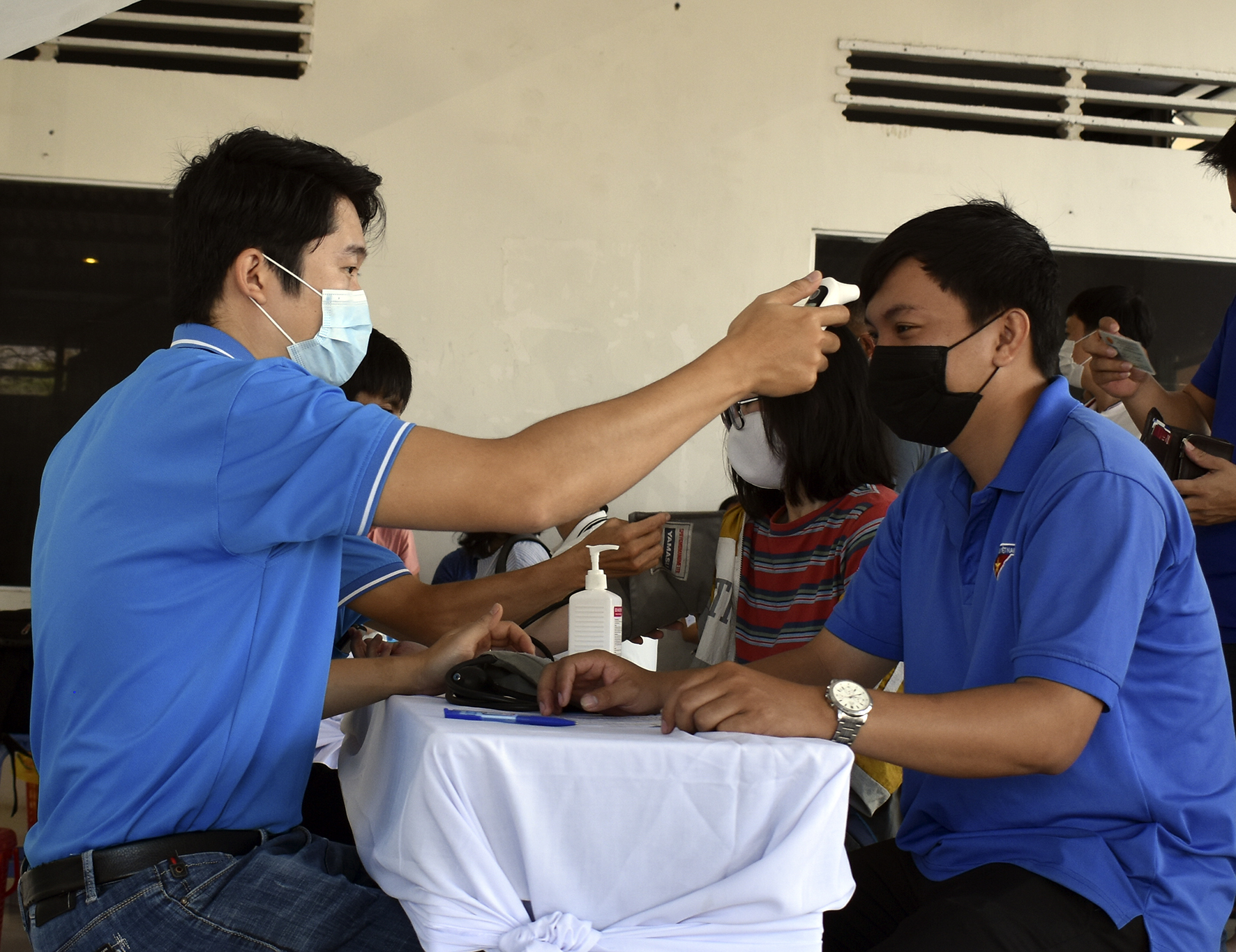 Người đến hiến máu được kiểm tra thân nhiệt. 