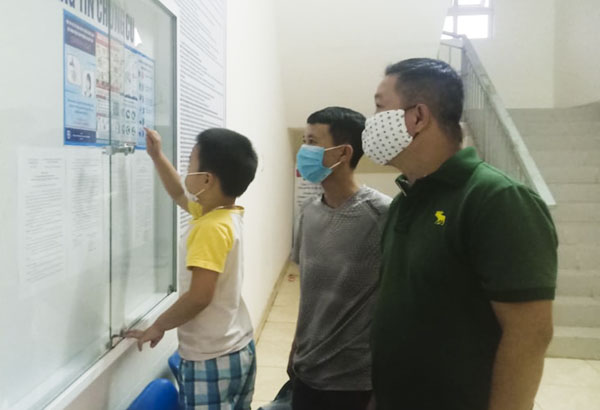 Ngươi dân chung cư Bình An (P10, TP. Vũng Tàu) xem hướng dẫn phòng chống dịch COVID-19 tại bảng tin chung cư.  Ảnh SONG BÌNH