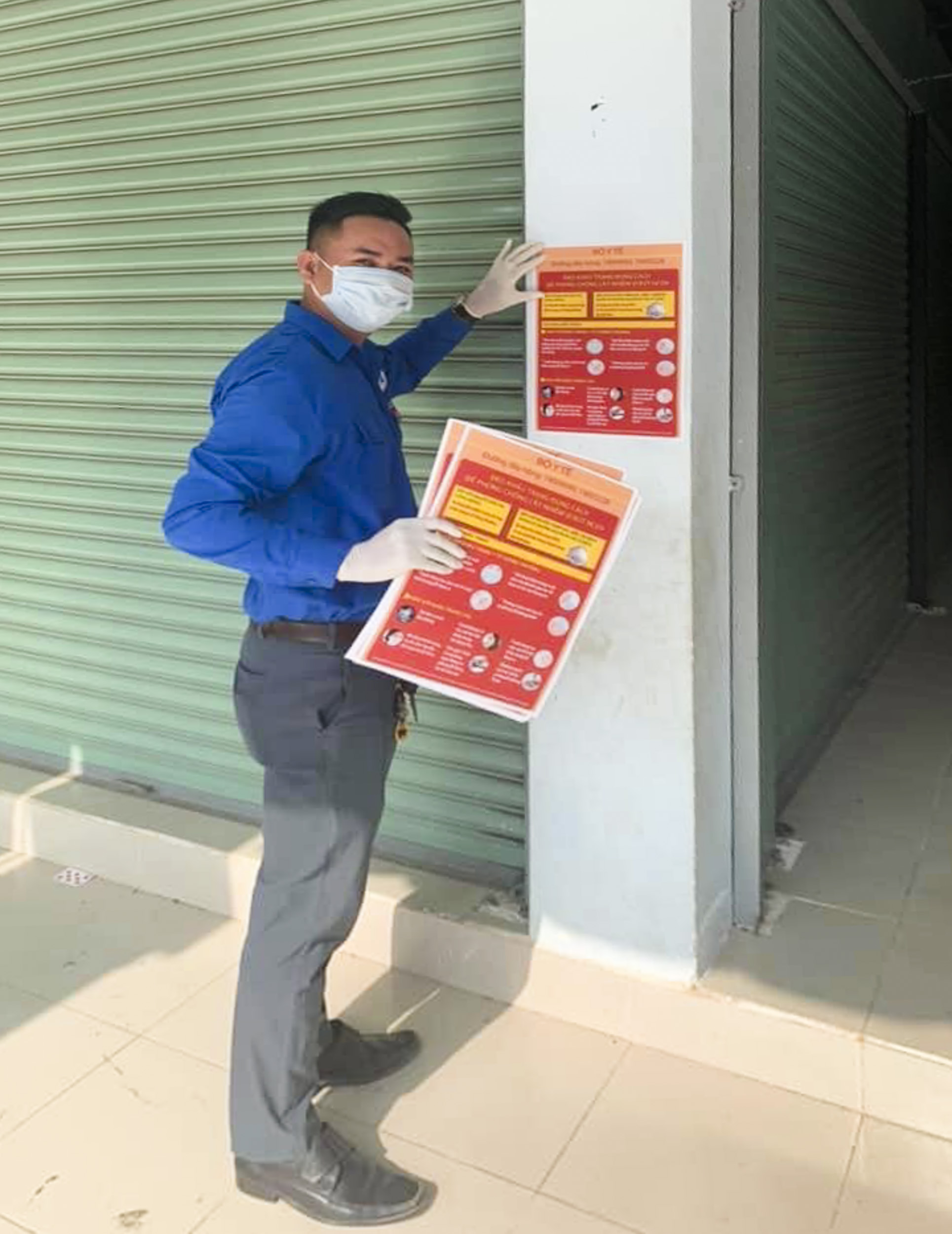 ĐVTN phường Hắc Dịch dán poster tuyên truyền về phòng chống dịch COVID-19 tại kios trong chợ Hắc Dịch.