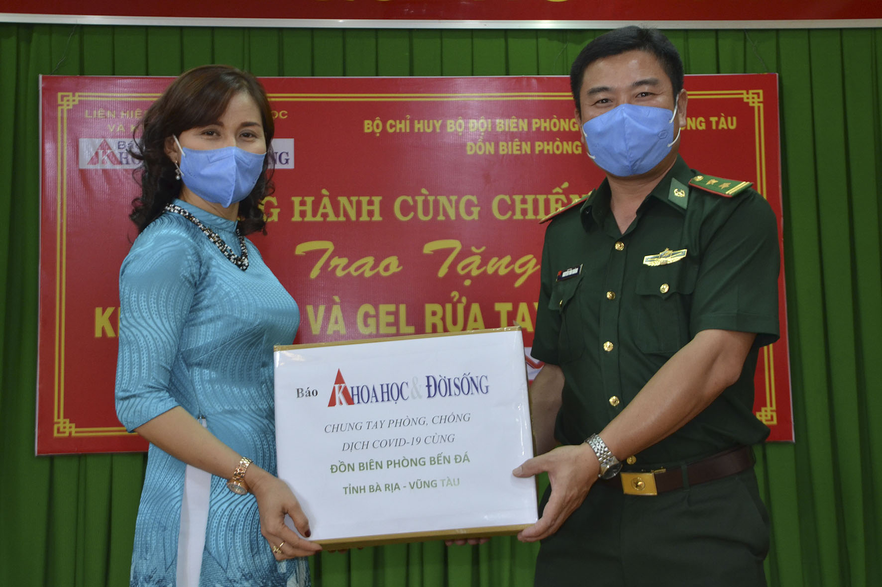 Nhà báo Bùi Hương, đại diện Báo Khoa học & Đời sống trao vật tư y tế đến Trung tá Nguyễn Văn Khánh, Đồn trưởng Đồn Biên phòng Bến Đá. 