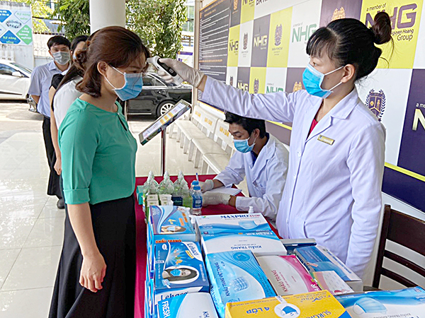 Cán bộ, GV, người lao động Trường ĐH Bà Rịa - Vũng Tàu đeo khẩu trang và được kiểm tra thân nhiệt trước khi vào làm việc tại trường. Ảnh: TUỆ LÂM  