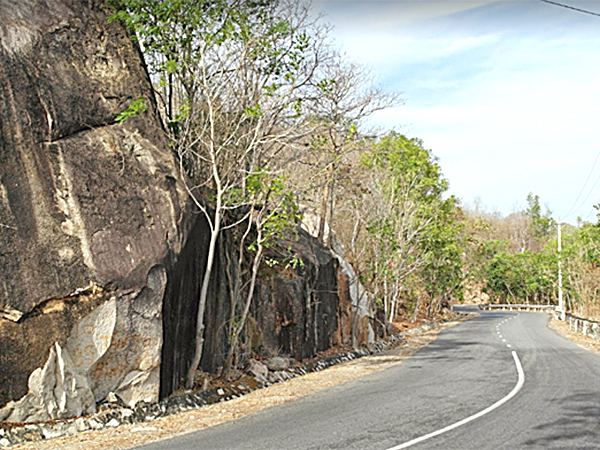 Đường lên núi Dinh như hình cánh cung, hai bên  là những tảng đá và cây cối.