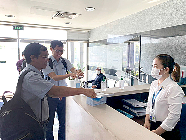 Khách rửa tay sát trùng và nhận khẩu trang trước khi vào làm việc tại Cảng CMIT (ấp Tân Lộc, phường Phước Hoà, TX . Phú Mỹ).