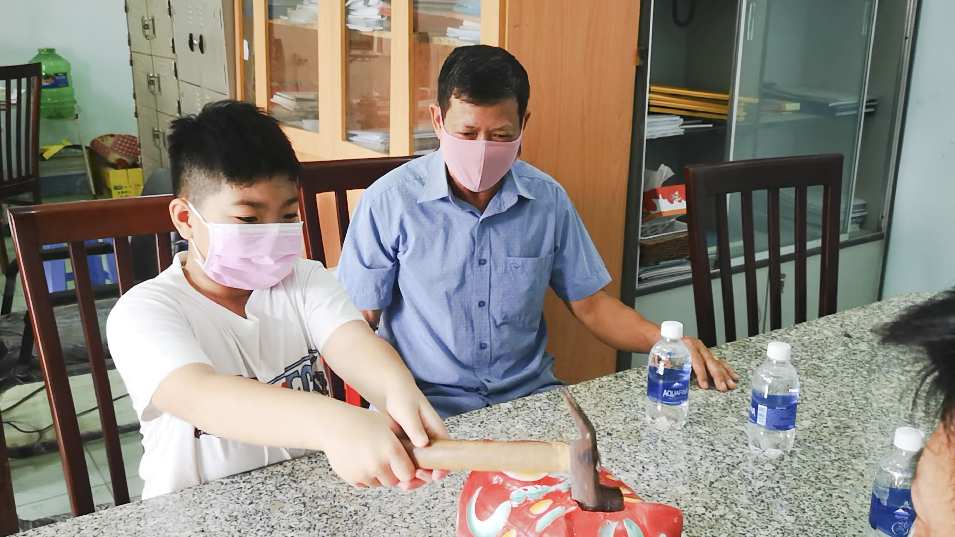 Lê Đức Anh (HS lớp 5.2 Trường TH Nguyễn Thị Định) đập heo đất ủng hộ phòng chống COVID-19 tại Văn phòng UBMTTQVN  phường Tân Phước (TX.Phú Mỹ)