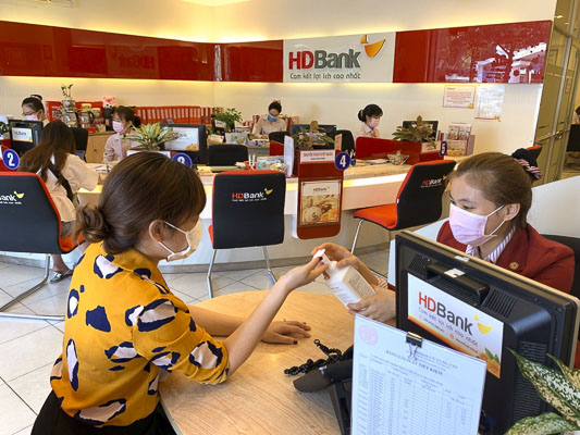 Các ngân hàng yêu cầu khách hàng khi đến giao dịch phải đeo khẩu trang, rửa tay sát khuẩn trước và sau khi giao dịch. Trong ảnh: Khách hàng giao dịch tại HDbank Vũng Tàu.