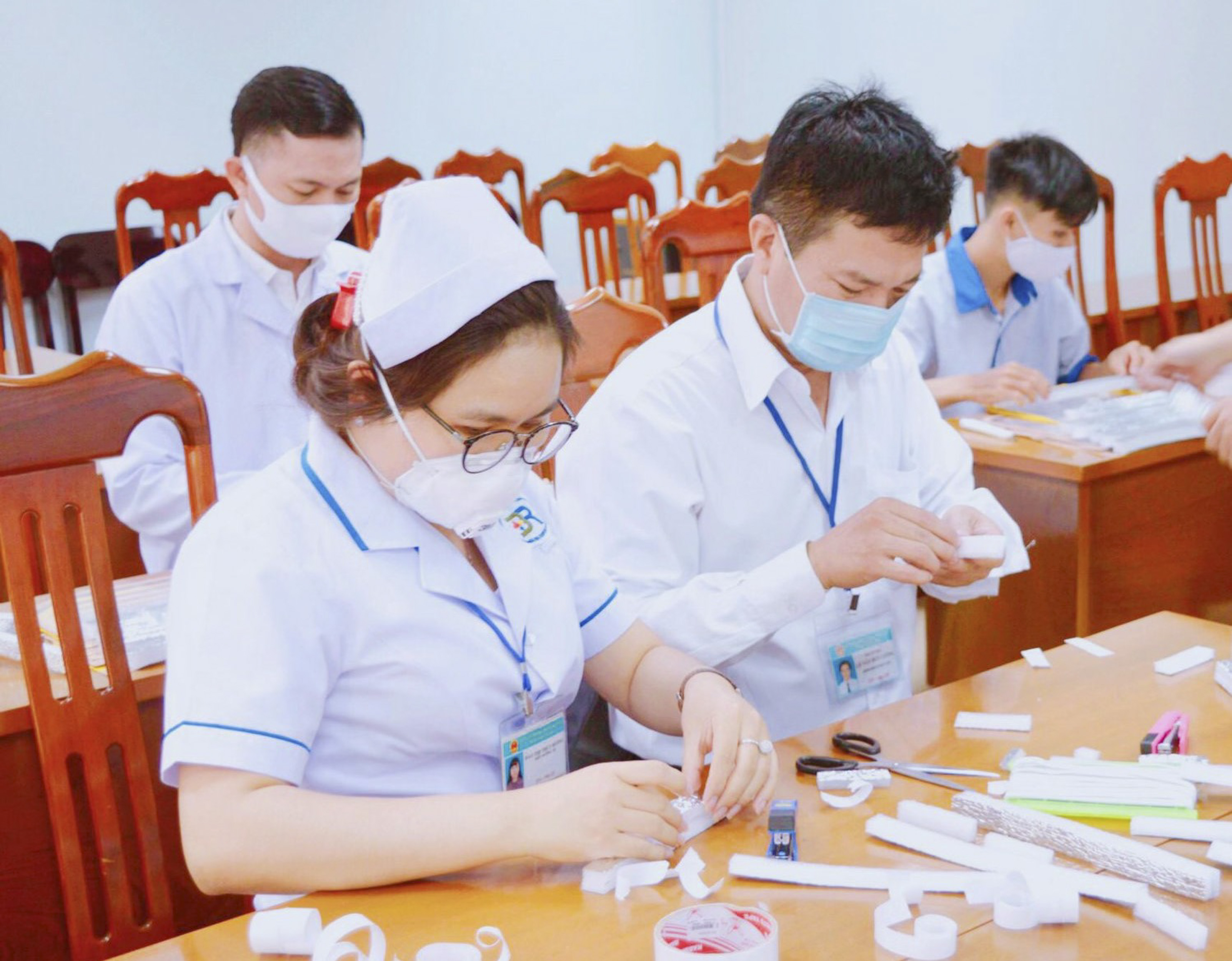 Các đoàn viên đang làm mặt nạ chắn giọt bắn.
