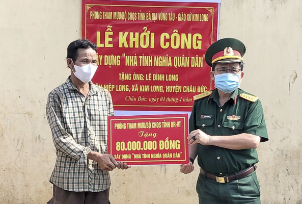 Đại tá Nguyễn Tâm Hùng, Phó Chỉ huy trưởng - Tham mưu trưởng Bộ CHQS tỉnh trao biểu trưng hỗ trợ 80 triệu đồng giúp gia đình ông Lê Đình Long xây dựng nhà.