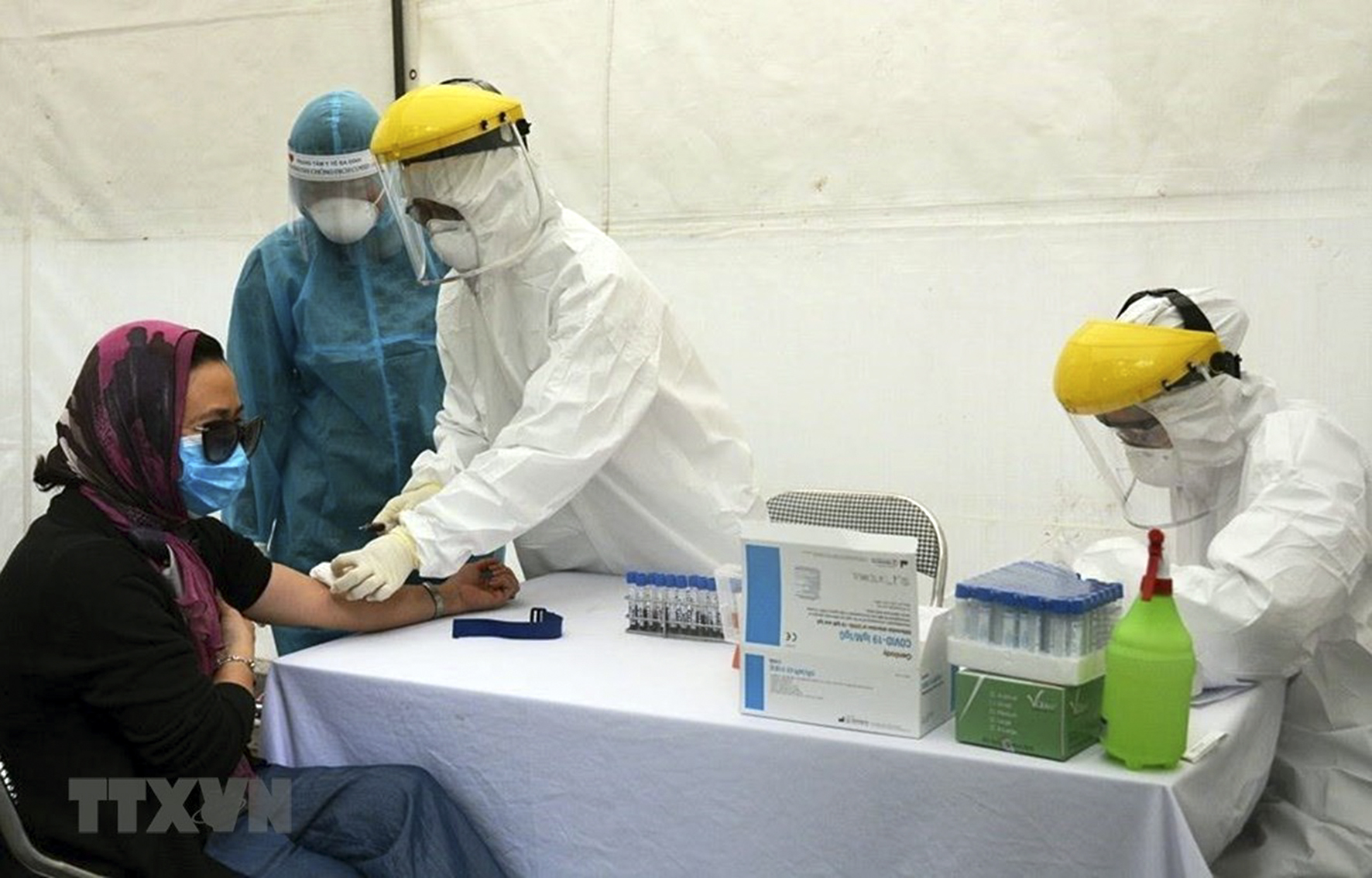 Lấy mẫu xét nghiệm virus SARS-CoV-2 cho người dân tại Trạm xét nghiệm nhanh quận Ba Đình. Ảnh: TTXVN.