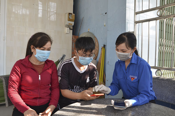 ĐVTN các phường, xã hướng dẫn người dân khai báo y tế. Trong ảnh: Chị Nguyễn Thị Đường, Bí thư Xã Đoàn Tân Hòa, TX.Phú Mỹ hướng dẫn gia đình chị Tiêu Thị Bảy (thôn Phước Long) thực hiện khai báo y tế toàn dân.