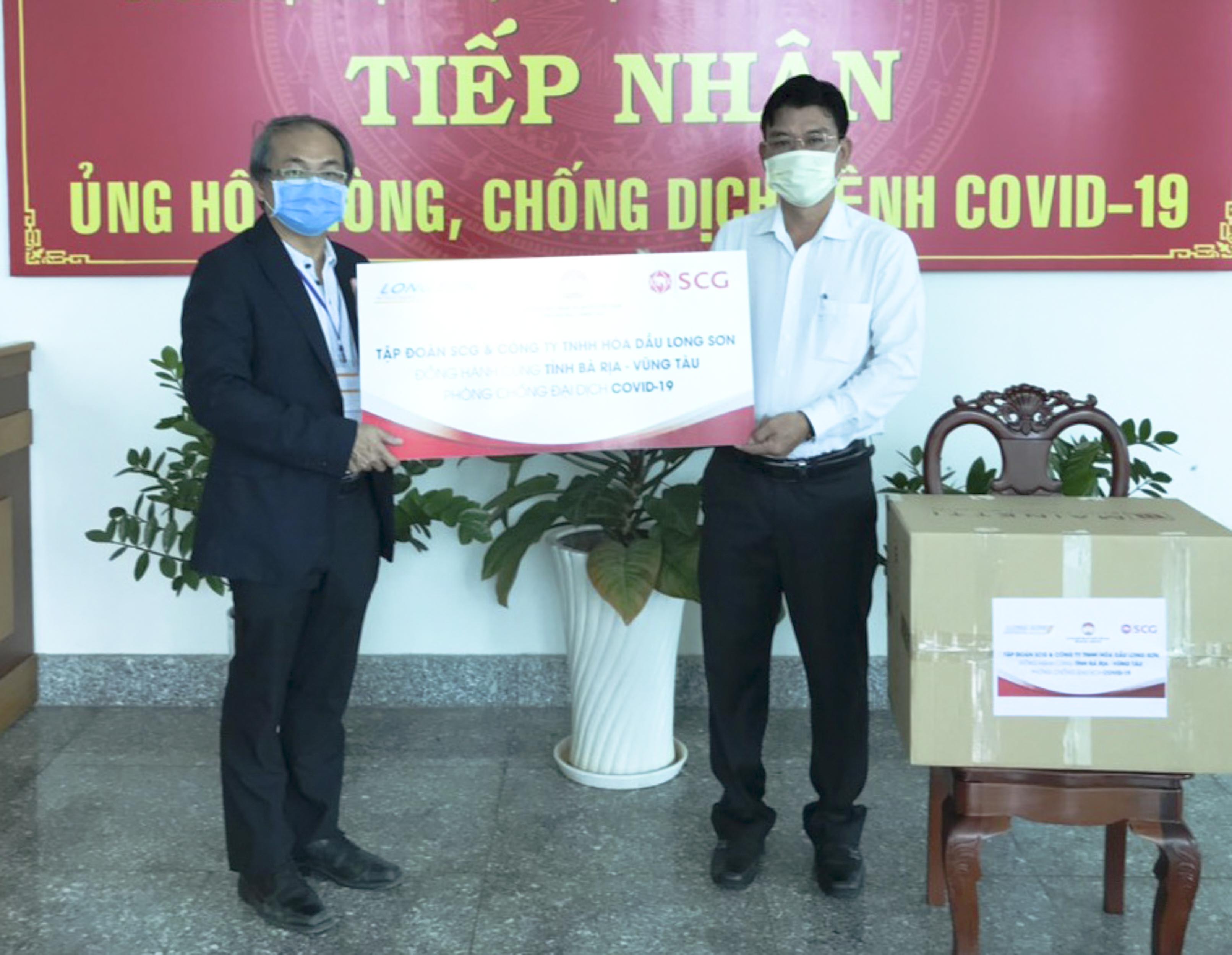 Ông Kitti Phadungchiwit (bên trái), Giám đốc  dự án xây dựng, Công ty TNHH Hóa dầu Long Sơn trao bảng biểu trưng ủng hộ công tác phòng,  chống dịch đến UBMTTQVN tỉnh.