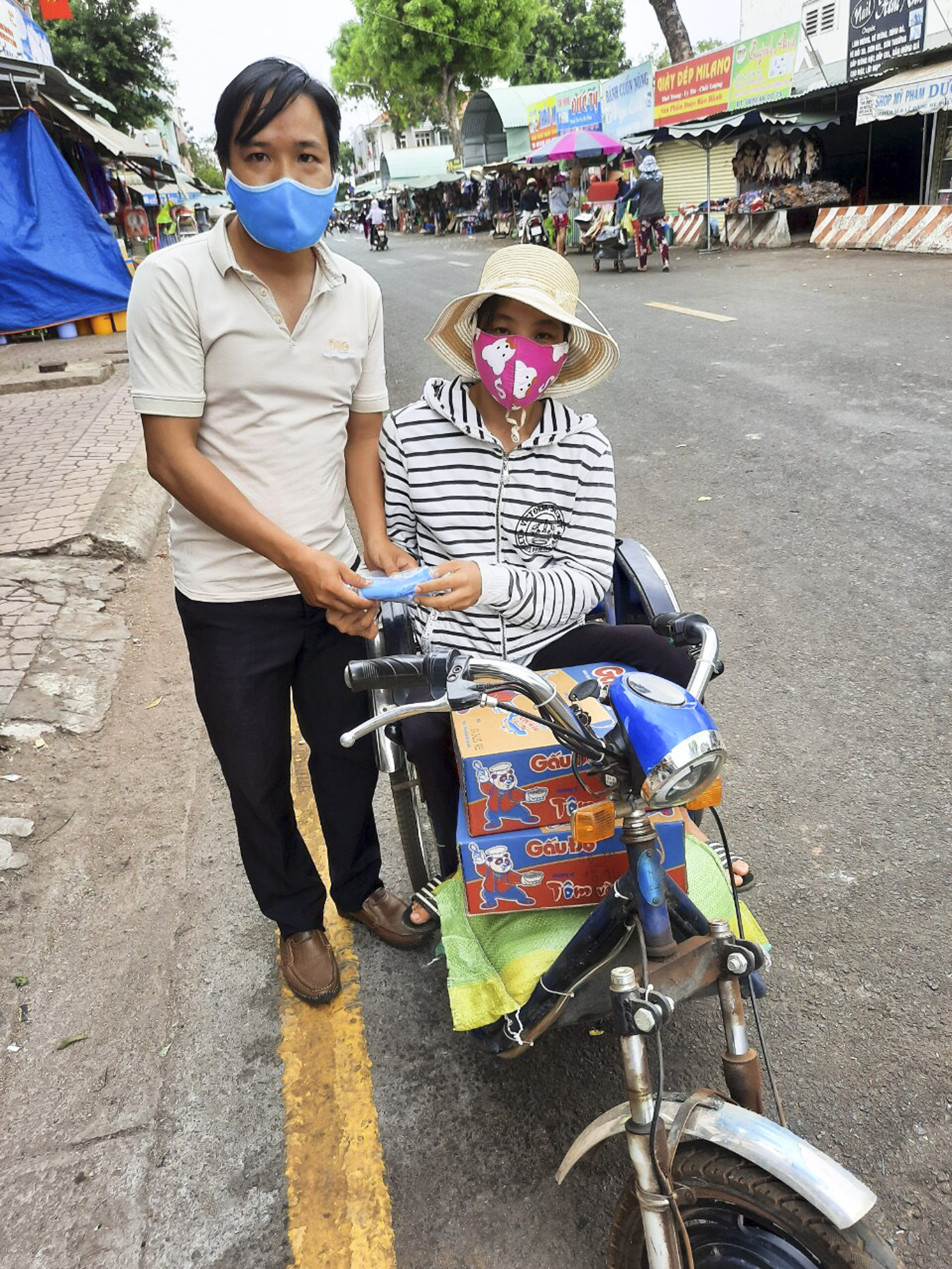 Anh Nguyễn Văn Nhân, Trưởng nhóm Thiện Sinh trao quà  cho người bán vé số trên địa bàn TT.Ngãi Giao. Ảnh: PHI DŨNG