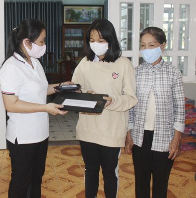 Cô Nguyễn Thị Hoa, Hiệu trưởng Trường THCS Vũng Tàu (bìa trái)  trao máy tính cho em Vũ Huỳnh Bích Ngọc, HS lớp 6.9. 