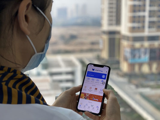 Người dân sử dụng ứng dụng VNPT Pay của VNPT để thanh toán khi mua sắm trong dịch COVID-19.