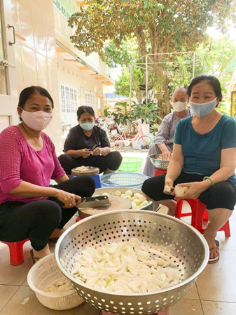 Chị Lợi (áo hồng) cùng nhóm thiện nguyện  Tịnh xá Ngọc Đức sơ chế thực phẩm.