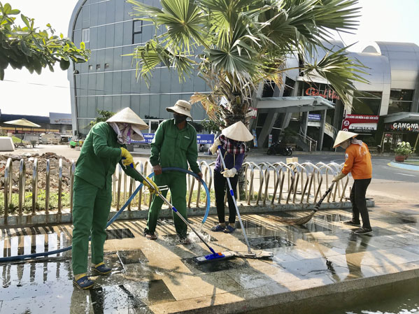 Công nhân Công ty VESCO làm sạch vỉa hè đoạn trước nhà hàng Gành Hào 2. Ảnh: QUANG VŨ