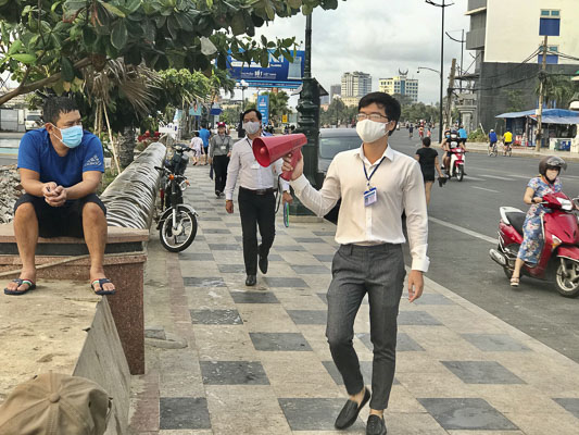 Cán bộ Phường 2 dùng loa phát thanh cầm tay để tuyên truyền, nhắc nhở người dân không tắm biển trong mùa dịch.