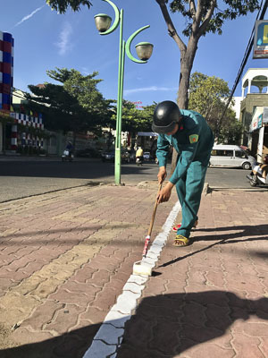 Cán bộ phường 4, TP. Vũng Tàu kẻ vạch phân định khu vực vỉa hè dành cho người đi bộ và khu vực dùng để thu phí xe máy của các hộ kinh doanh trên đường Lê Lợi.