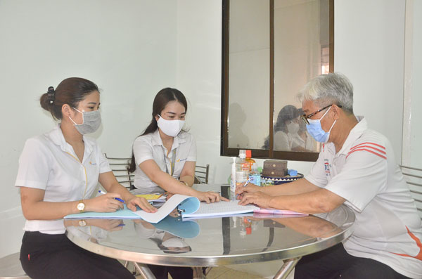 Nhân viên Bưu điện TP.Vũng Tàu chi trả lương hưu tại nhà cho ông Vũ Văn Noãn (257/3, Lê Hồng Phong, TP.Vũng Tàu) vào chiều 15/4. Ảnh: THI PHONG