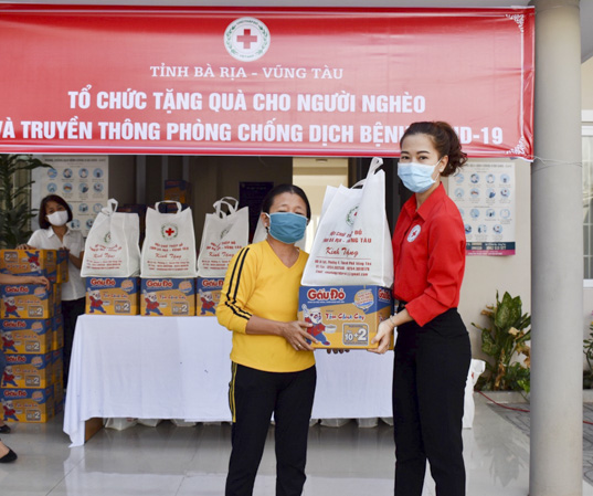 Đại diện Hội CTĐ tỉnh (bìa phải) trao quà cho người nghèo. Ảnh: PHI DŨNG