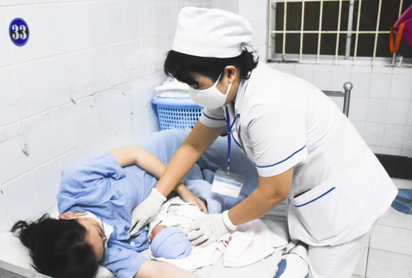 Nữ hộ sinh chăm sóc cho một sản phụ sau sinh tại Khoa sản BV. Lê Lợi. Ảnh: ANH ĐÀO