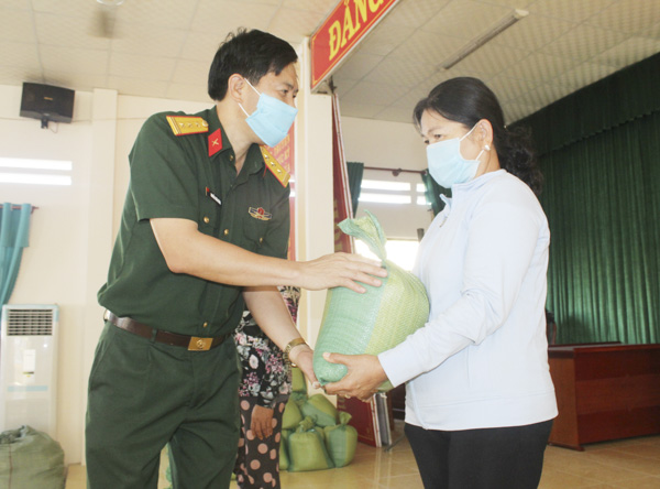 Thượng tá Nguyễn Xuân Công, Phó Chủ nhiệm Chính trị Bộ CHQS tỉnh trao quà cho hộ nghèo TT.Phước Hải, huyện Đất Đỏ. Ảnh: MINH NHÂN