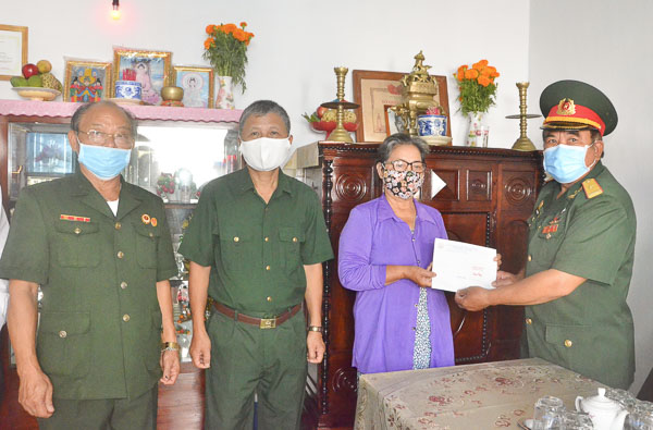 Ông Phạm Quang Lập (phải), đại diện Ban Liên lạc Sư đoàn Sao Vàng, Phó Chủ tịch Thường trực Hội Hỗ trợ gia đình liệt sĩ tỉnh trao quà cho bà Nguyễn Thị Bảy.