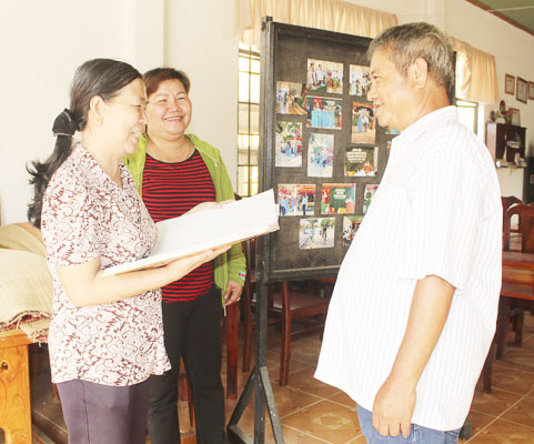 Bà Văn Thị Bạch (bên trái), Trưởng Ban Công tác Mặt trận KP.Hương Giang, phường Long Hương, TP.Bà Rịa vận động người dân ký cam kết gia đình không có người vi phạm quy định ATGT.