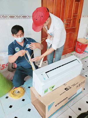 Nhân viên Công ty CP Thương mại - Dịch vụ - Vận tải - Điện máy 121 lắp máy lạnh cho khách.