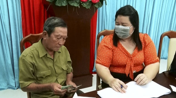 Cán bộ Hội NNCĐ da cam và BTXH tỉnh trao tiền cho cho bệnh nhân nghèo.