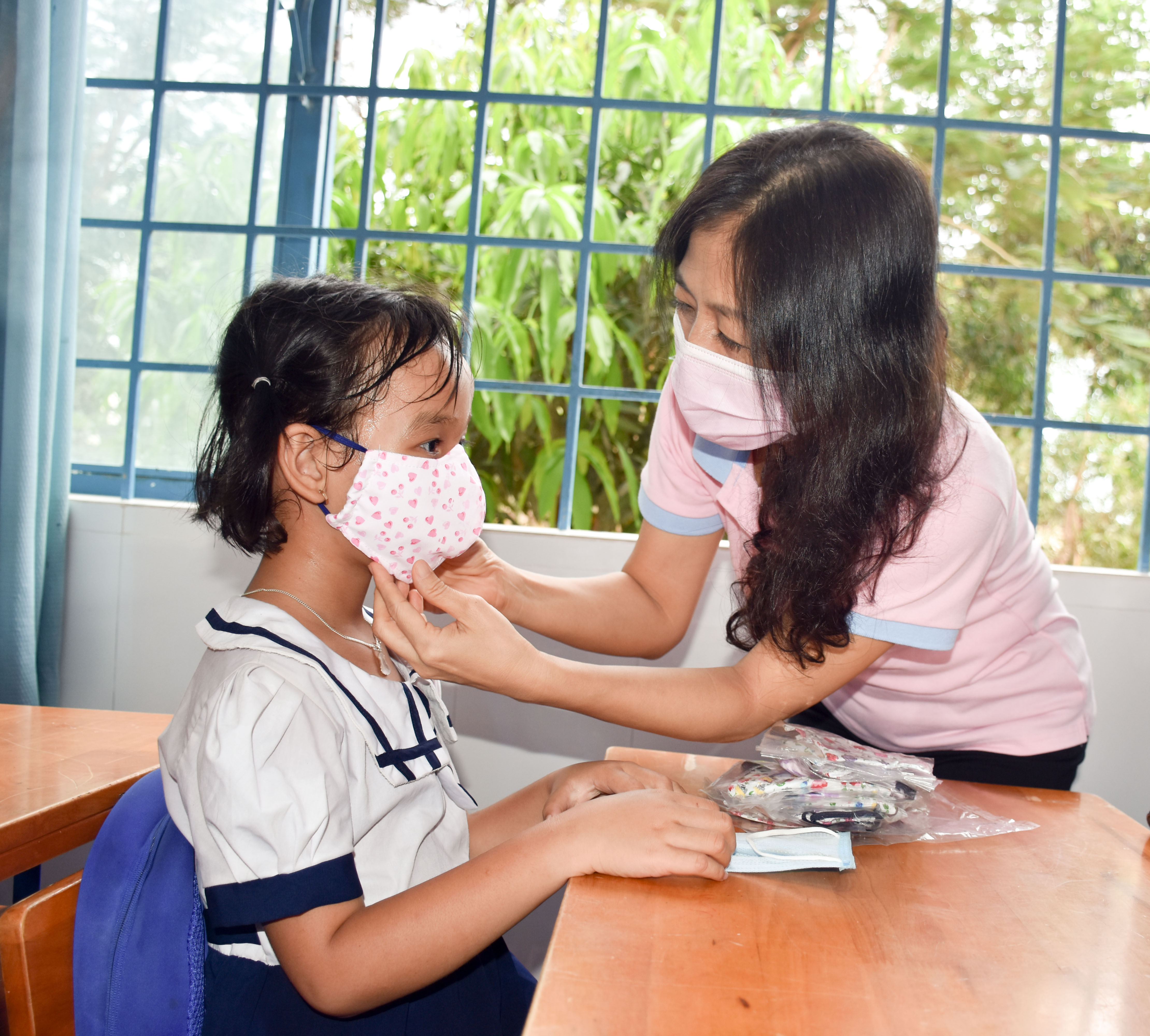 Thành viên nhóm thiện nguyện tặng khẩu trang cho các em HS tại Trường TH Lý Tự Trọng.