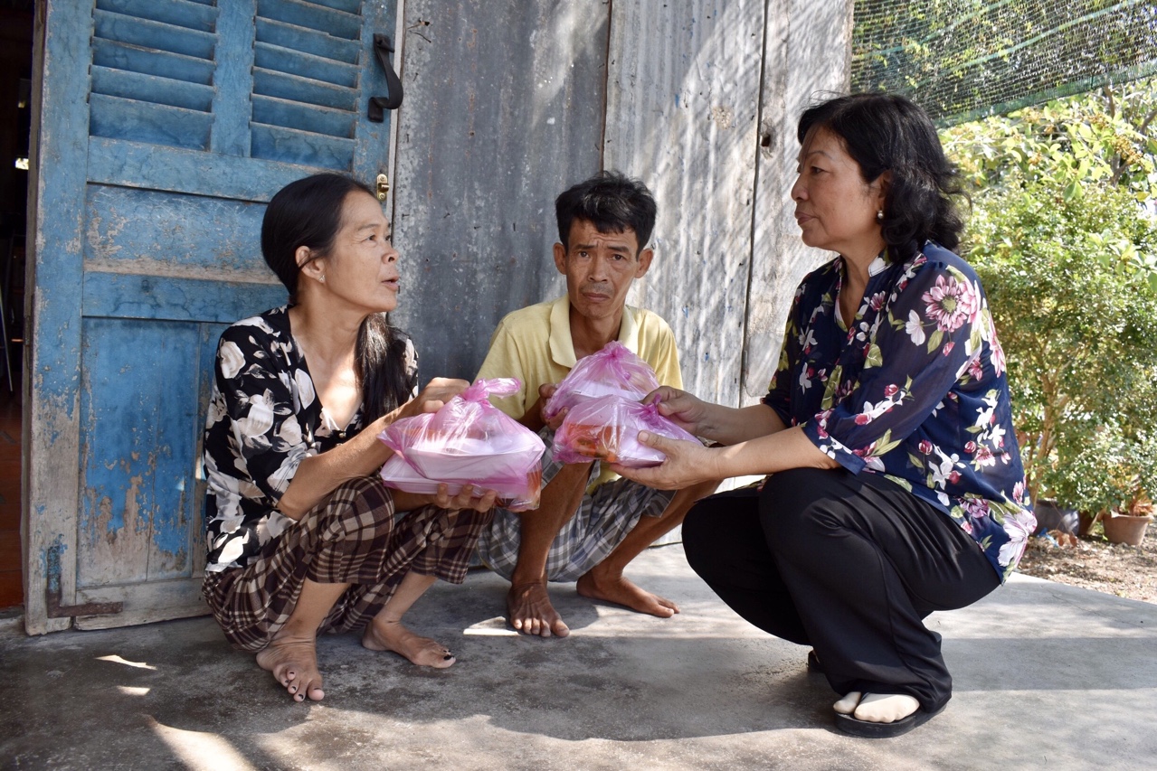 Bà Nguyễn Thị Quang động viên, thăm hỏi và phát cơm cho hai chị em bà Mộng Thu.