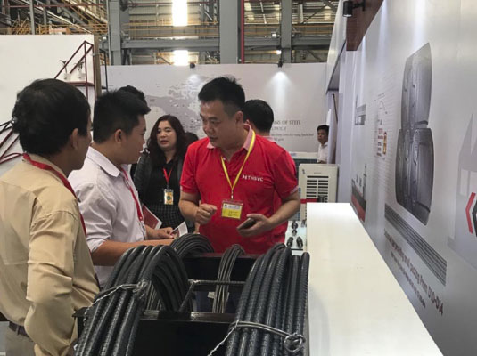 Nhân viên Công ty TNHH Thép TungHo Việt Nam giới thiệu sản phẩm mới tới khách hàng. Ảnh: TRÀ NGÂN