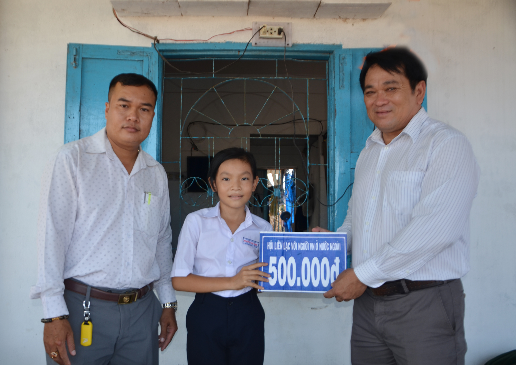 Ông Nguyễn Văn Sâm, Phó Chủ tịch Hội LLNVNONN xã Phước Hưng trao tiền hỗ trợ cho em Nguyễn Mai Hương, HS lớp 5E, Trường TH Hoàng Văn Thụ. Hai anh em Hương được nhận hỗ trợ từ khi vào lớp 1 đến nay.