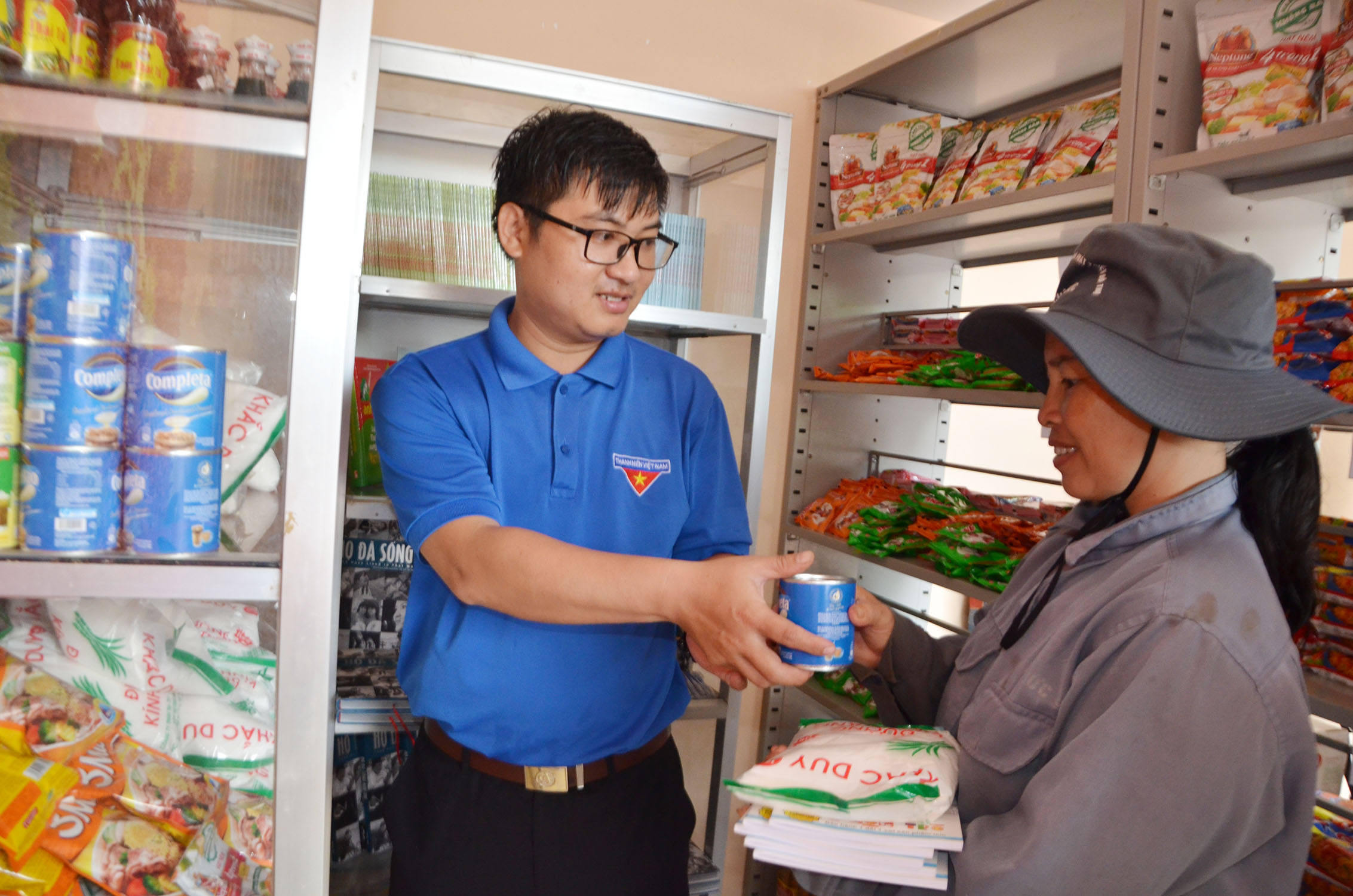 Anh Trần Văn Phúc, cán bộ Huyện Đoàn hướng dẫn chị Trịnh Thị Hoa (thị trấn Ngãi Giao) “mua hàng” miễn phí.