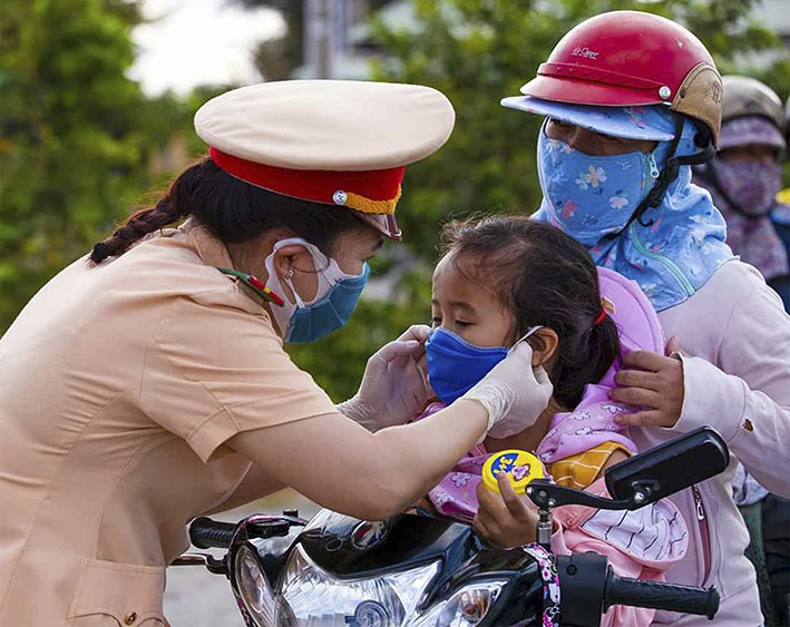 Cán bộ, chiến sĩ CSGT (PC08) - Công an tỉnh phát khẩu trang cho người dân phòng, chống dịch COVID-19 trên tuyến Quốc lộ 51.
