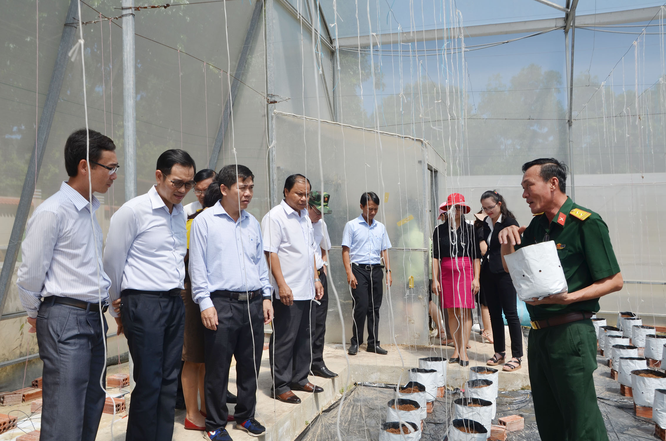 Trung tá Đoàn Xuân Sơn, Chính ủy Trung đoàn  Minh Đạm (phải) giới thiệu đến đoàn về giá thể trồng rau, dưa lưới tại khu vực tăng gia của đơn vị.