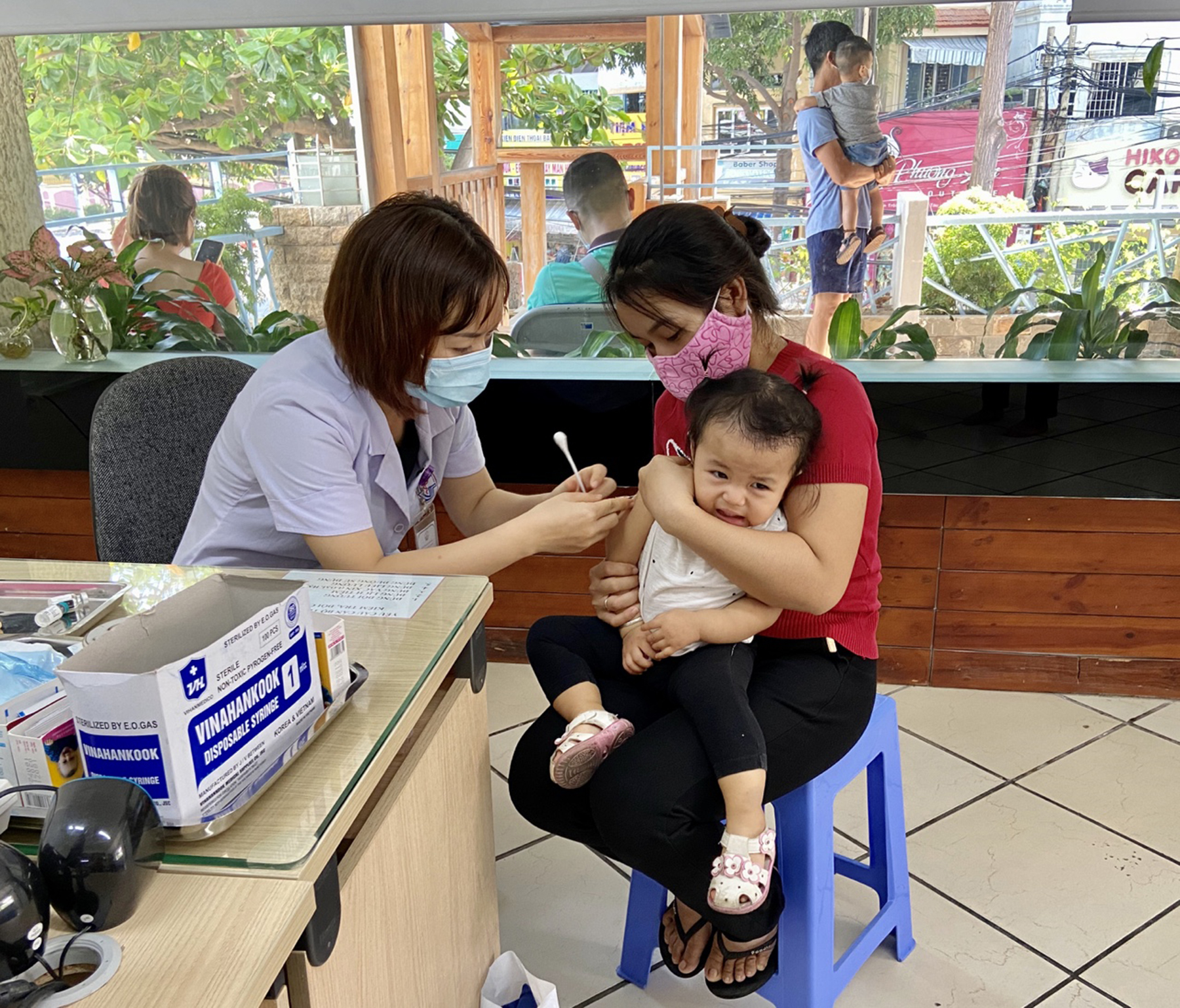 Nhân viên y tế Phòng khám đa khoa Vũng Tàu chích ngừa cho trẻ.