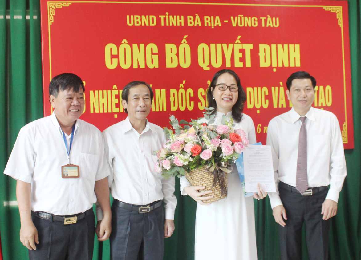 Ông Trần Văn Tuấn, Phó Chủ tich UBND tỉnh và ông Trương Thanh Phong, Giám đốc Sở Nội vụ trao Quyết định bổ nhiệm và tặng hoa chúc mừng bà Trần Thị Ngọc Châu.