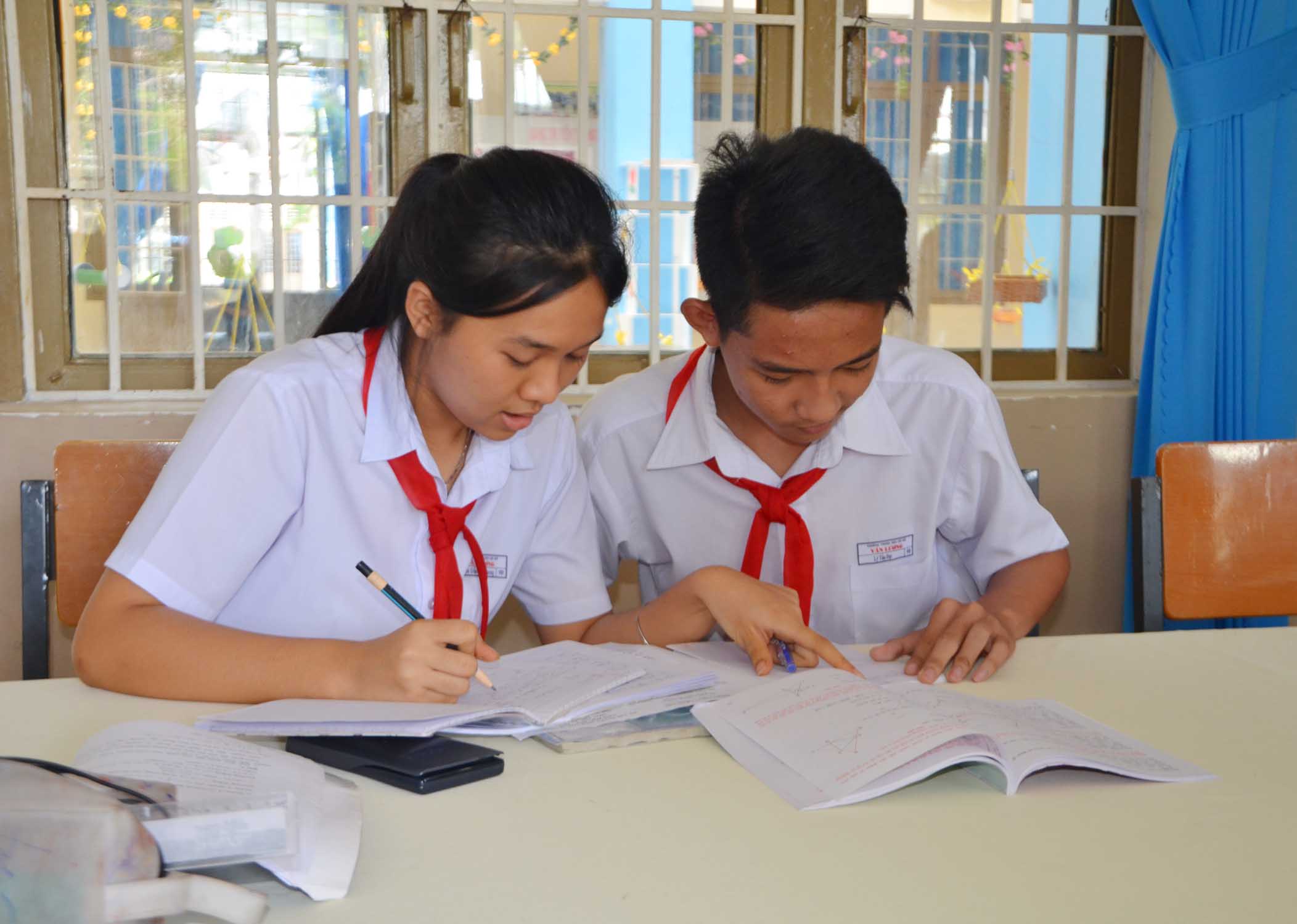 Nguyễn Trần Lan Phương hướng dẫn bạn Lý Tấn Đạt học môn Toán. 