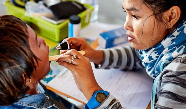 Kiểm tra răng miệng cho một trẻ em Campuchia.