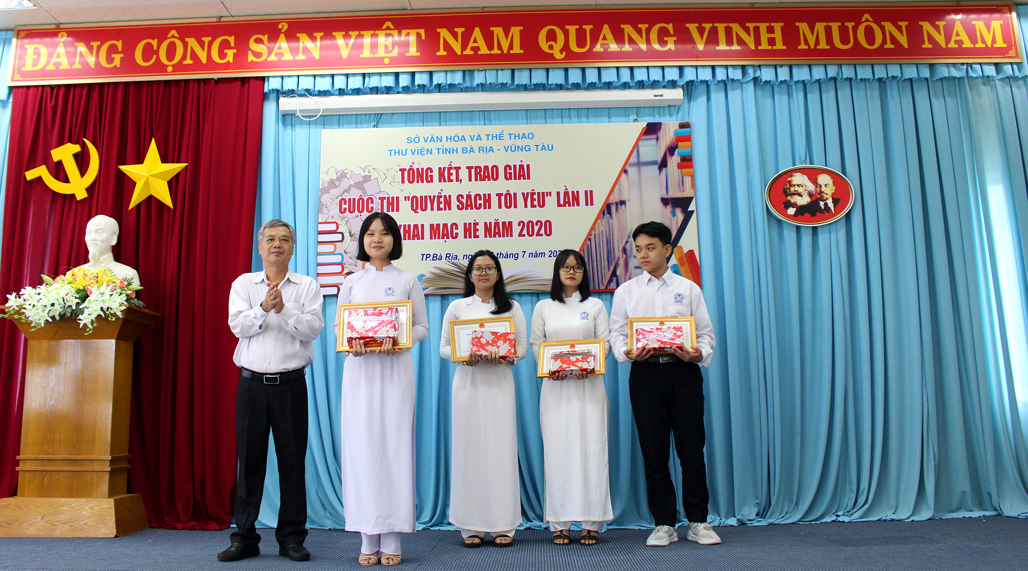 Ông Trần Minh Thế, Giám đốc Thư viện tỉnh trao các giải thưởng cho HS có bài viết cảm nhận hay về những cuốn sách yêu thích trong cuộc thi “Quyển sách tôi yêu”.
