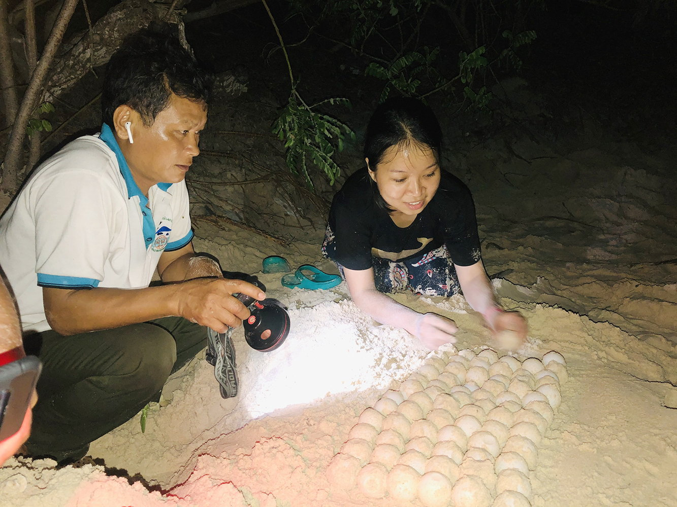 Tình nguyện viên Phạm Thị Ngọc Hạnh, đến từ TP.Hồ Chí Minh hào hứng với nhiệm vụ đào và di dời trứng rùa từ hố đẻ về nơi ấp. Ảnh: ĐĂNG KHOA