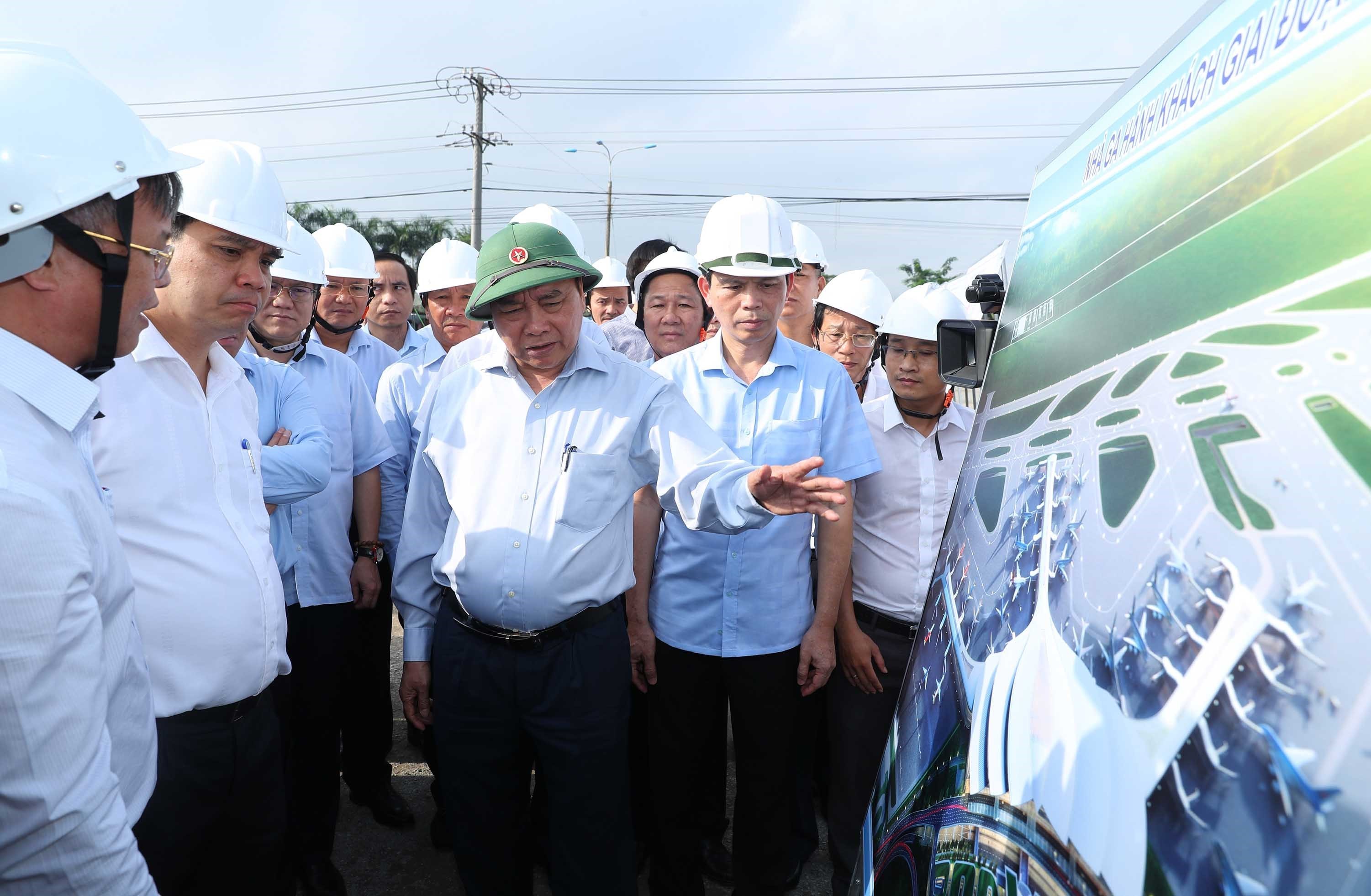 Thủ tướng Nguyễn Xuân Phúc xem bản đồ  quy hoạch sử dụng đất khu dân cư tái định cư  xã Lộc An - Bình Sơn, huyện Long Thành.  Ảnh: THỐNG NHẤT