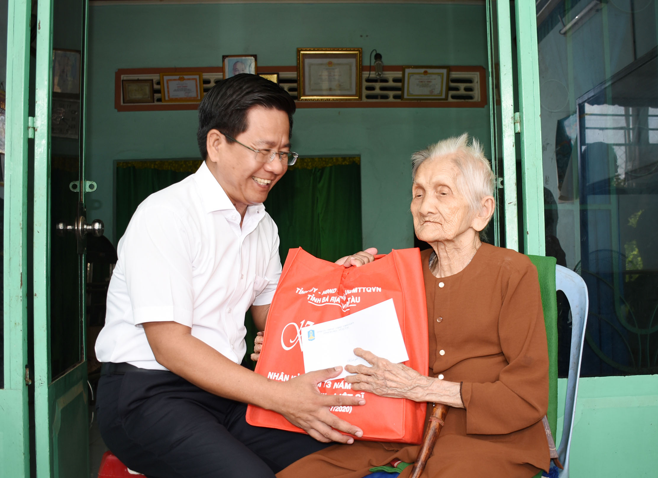 Ông Bùi Chí Thành, Ủy viên Dự khuyết Trung ương Đảng, Ủy viên Ban Thường vụ Tỉnh ủy, Chủ tịch UBMTTQVN tỉnh thăm, tặng quà Mẹ VNAH Lại Thị Bạn (xã Nghĩa Thành). Ảnh: NGỌC BÍCH